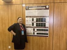 Lisa Anderson standing next to her poster at the 2022 SSIB meeting.